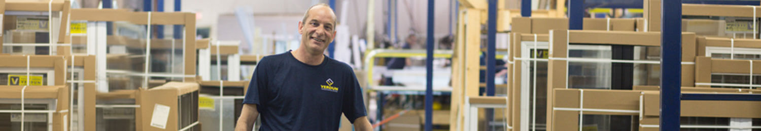 A Verdun windows and doors expert standing in front of a slew of manufactured windows.