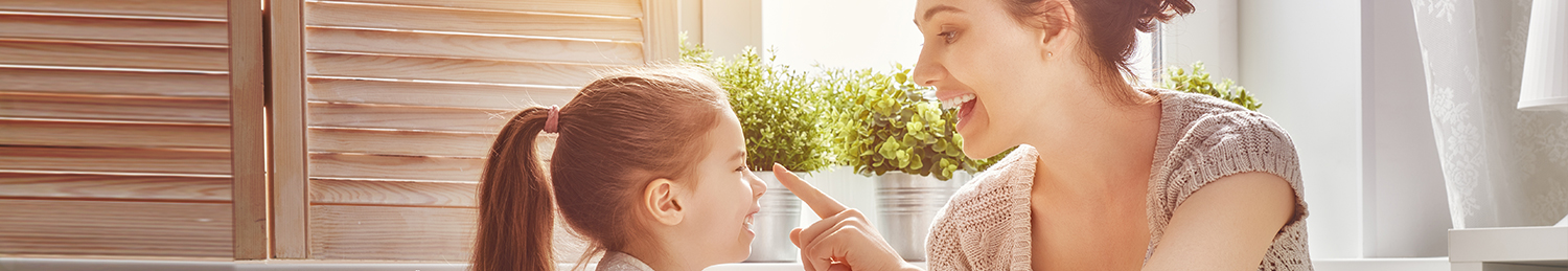 A mother with her daughter in front of a large window.