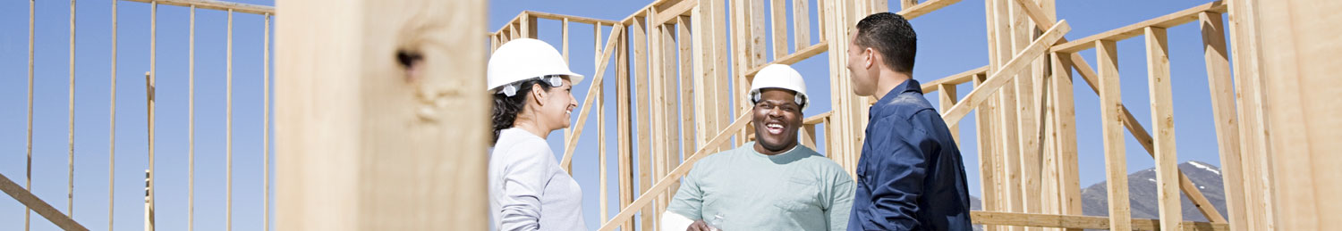 Three contractors discussing the installation of windows for new home.